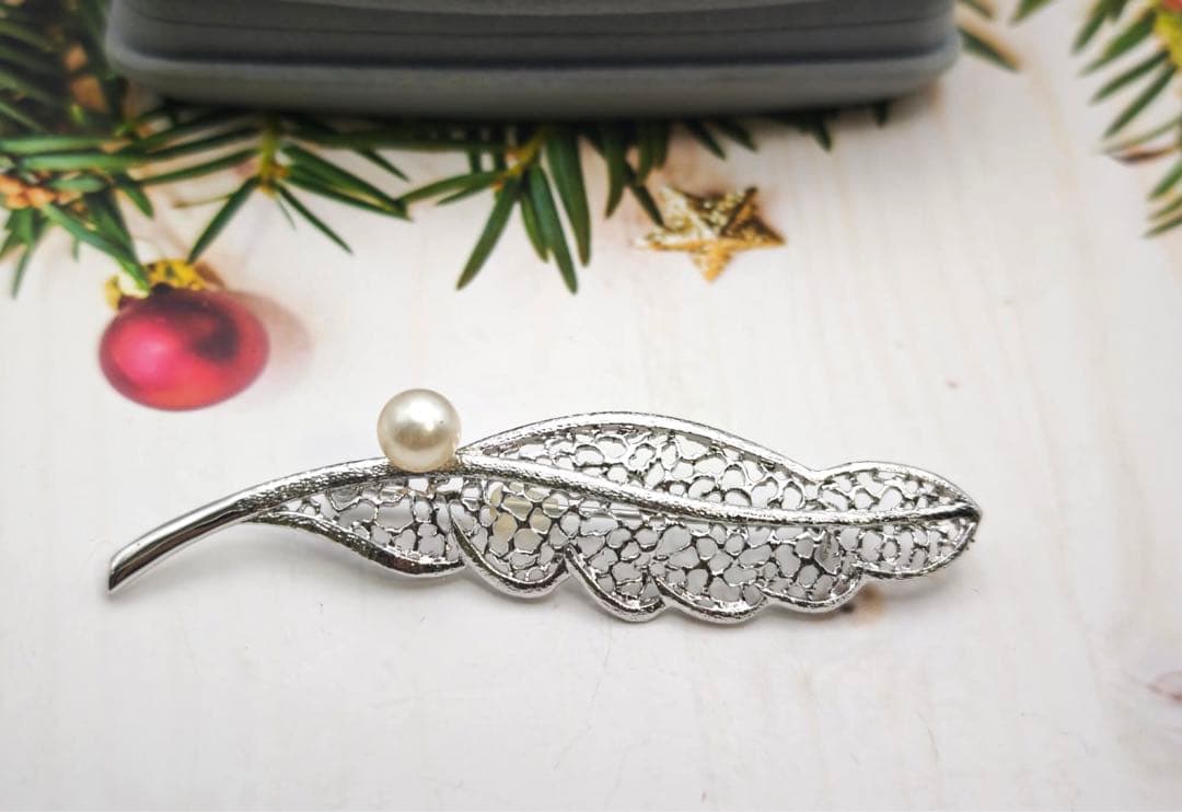 タサキのシルバーブローチはタヒチ産真珠と羽根のモチーフで装飾されています。