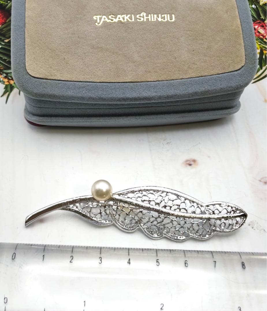 タサキのシルバーブローチはタヒチ産真珠と羽根のモチーフで装飾されています。