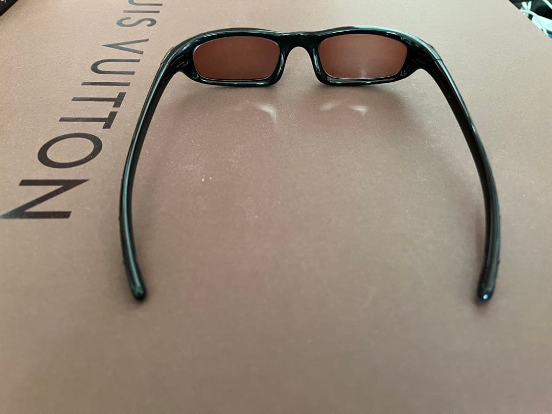 Oakley スポーツサングラス 黒 オレンジの度付きレンズ