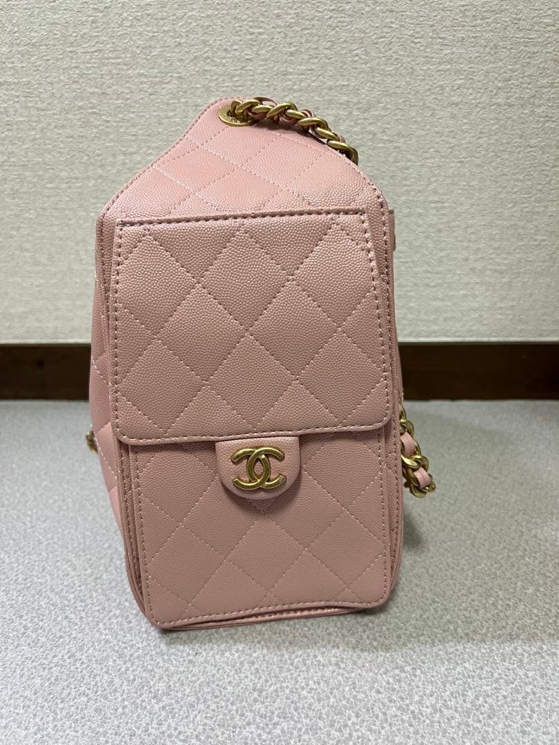 ゴールドチェーンが付いたピンクのキルティングレザーショルダーバッグ。