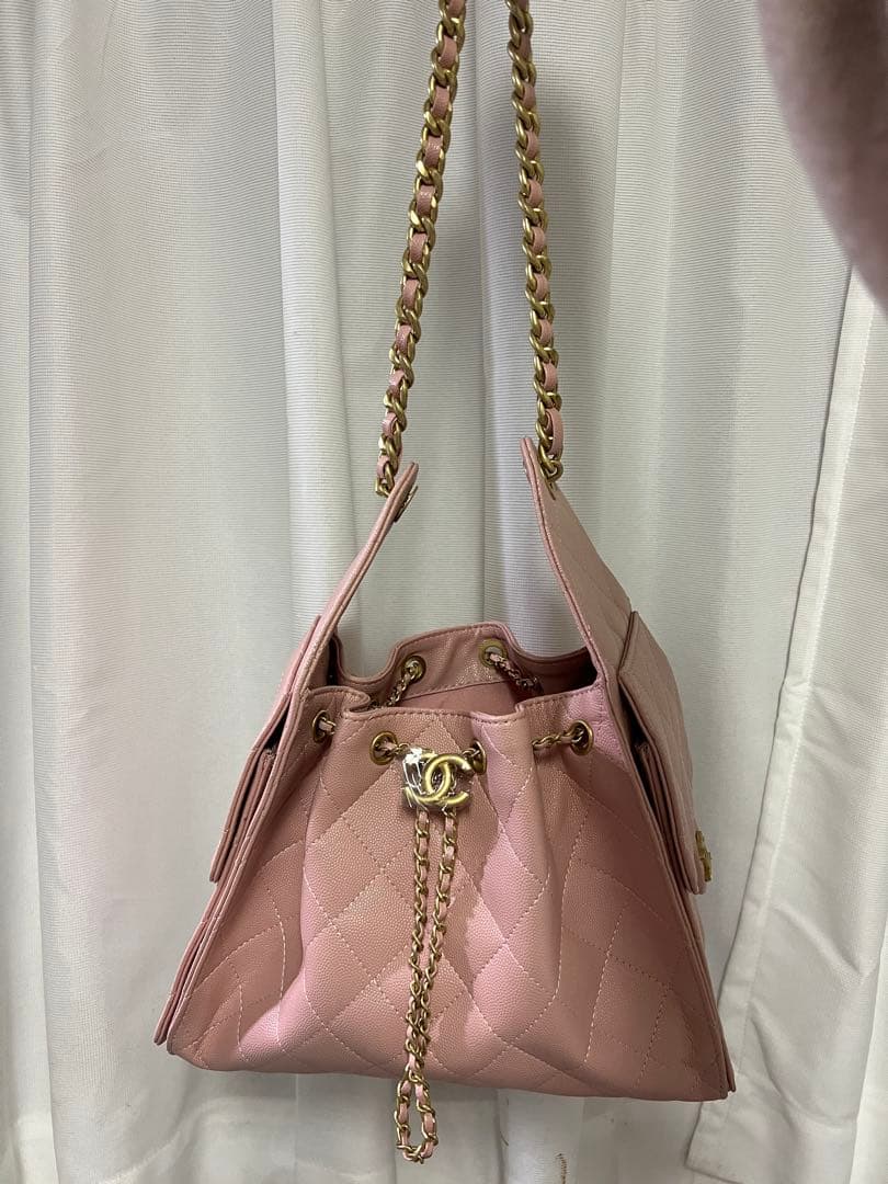 ゴールドチェーンが付いたピンクのキルティングレザーショルダーバッグ。