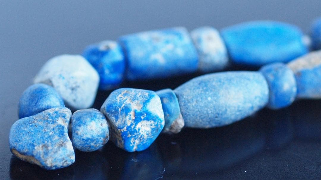 古代濃紺ラピスの管玉や丸玉をほぼ左右対称に編み、トップに斧型や多面体、80個の連