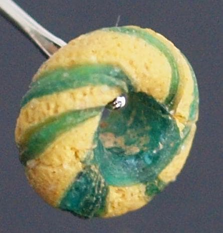 クリアな青緑に鮮やか黄で、回転する輪状モチーフを描くモザイク平玉　前後～6C頃の